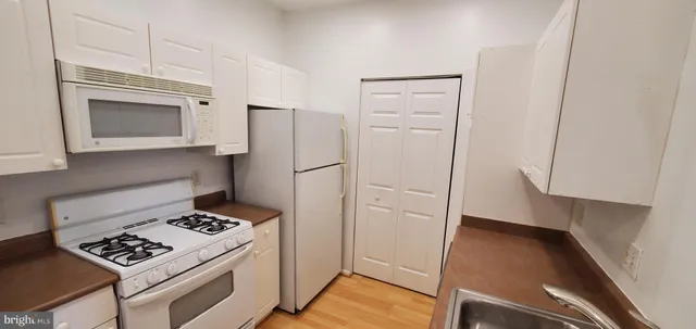 a utility room with a stove and cabinets