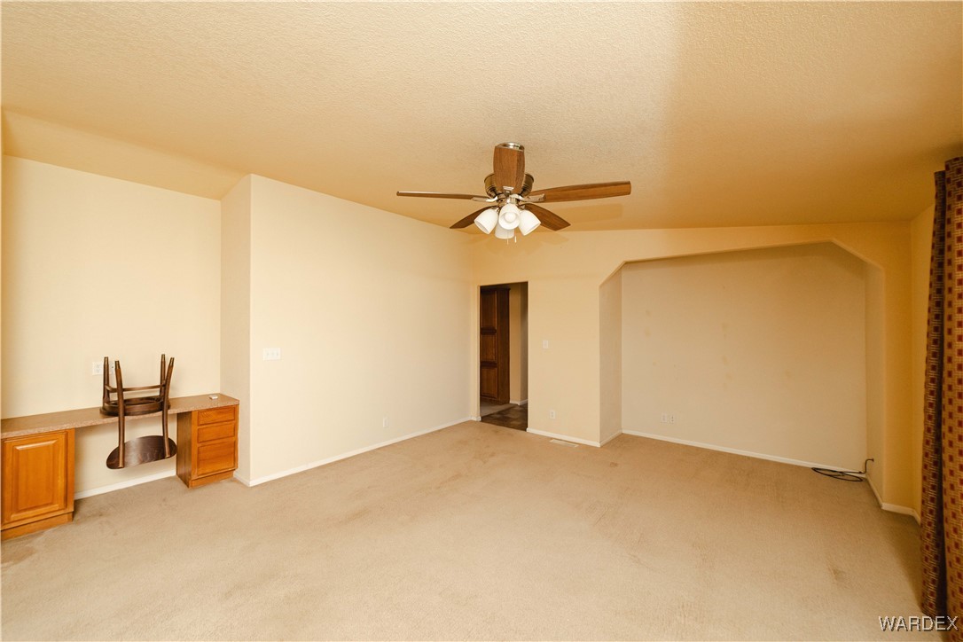 3375 West Rancho Road Golden Valley, AZ 86413 - Photo 13 of 33 a view of a room with a stylish ceiling fan and entryway