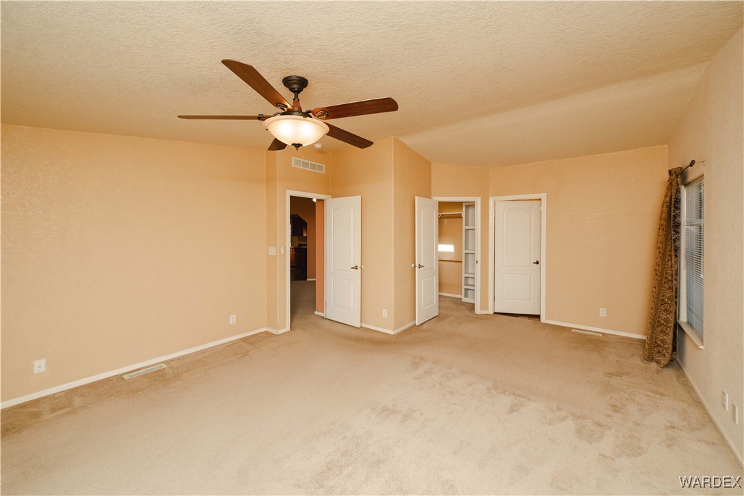 3375 West Rancho Road Golden Valley, AZ 86413 - Photo 18 of 33 an empty room with closet and a ceiling fan