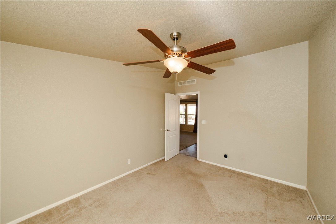 3375 West Rancho Road Golden Valley, AZ 86413 - Photo 31 of 33 an empty room with a ceiling fan and a window