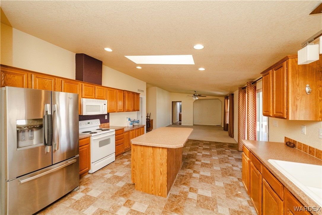 3375 West Rancho Road Golden Valley, AZ 86413 - Photo 8 of 33 a large kitchen with kitchen island a large counter top space a sink stainless steel appliances and cabinets