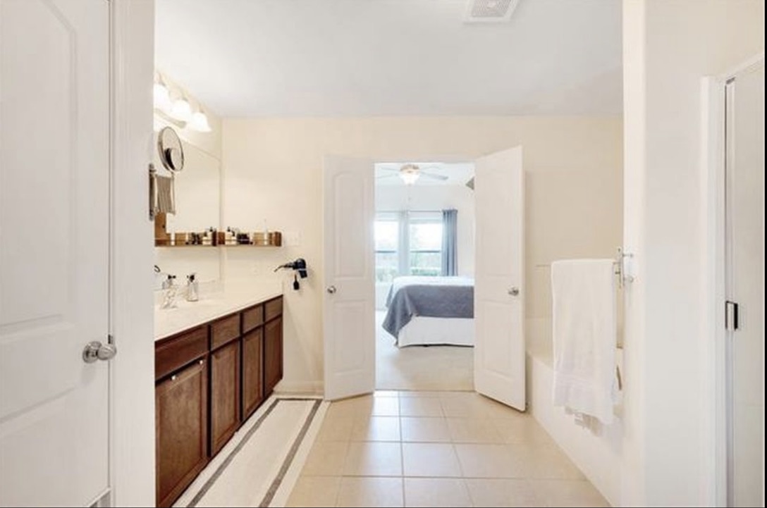 13405 Clara Martin Road Manor, TX 78653 - Photo 14 of 26 Ensuite bathroom with vanity, light tile patterned floors, and a tub to relax in