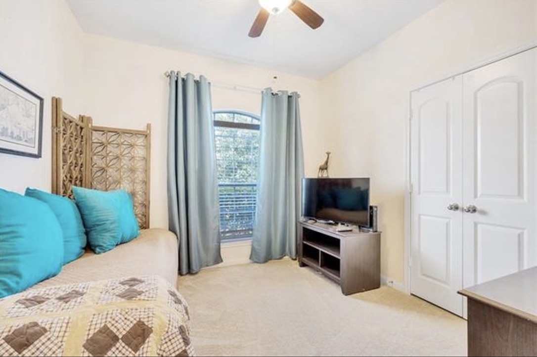 13405 Clara Martin Road Manor, TX 78653 - Photo 15 of 26 Bedroom featuring light colored carpet, a closet, and a ceiling fan