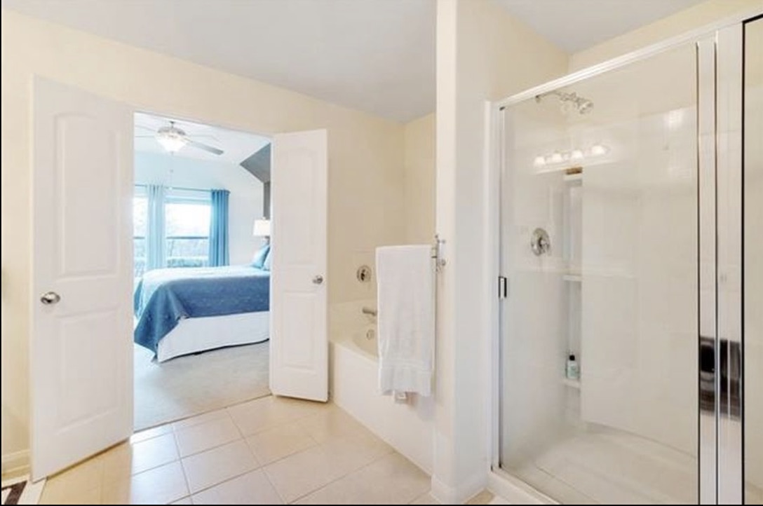 13405 Clara Martin Road Manor, TX 78653 - Photo 16 of 26 Ensuite bathroom with a stall shower, a garden tub, light tile patterned floors, and ceiling fan