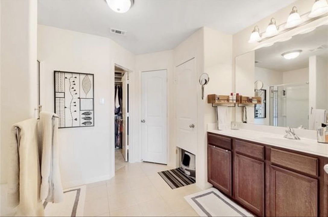 13405 Clara Martin Road Manor, TX 78653 - Photo 19 of 26 Full bath featuring vanity, a stall shower, a walk in closet, and light tile patterned floors