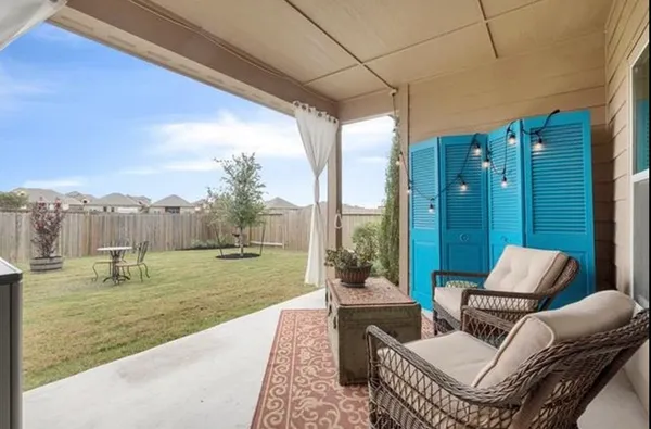 a view of a patio with couches chairs and a yard