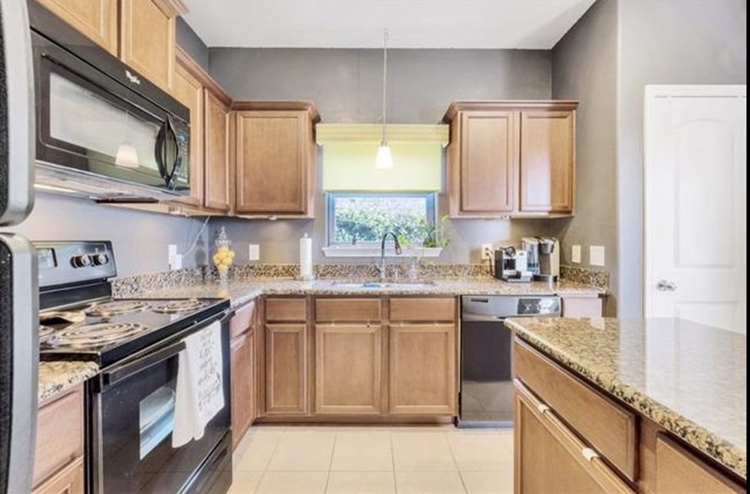 13405 Clara Martin Road Manor, TX 78653 - Photo 6 of 26 Kitchen with black appliances, pendant lighting, light stone countertops, and light tile patterned flooring