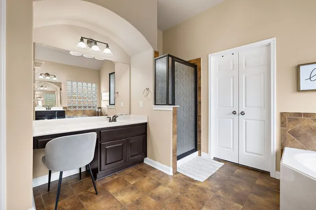 a spacious bathroom with a double vanity sink a mirror and a shower