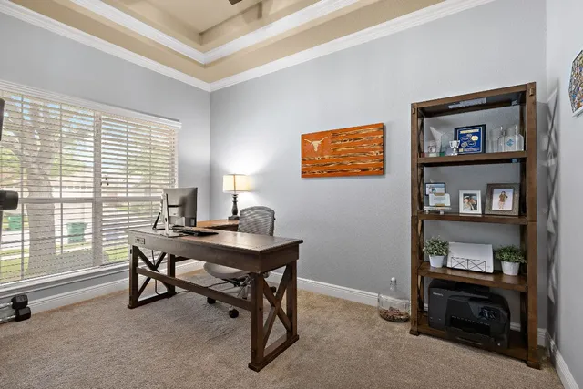 a view of a workspace with furniture and a window