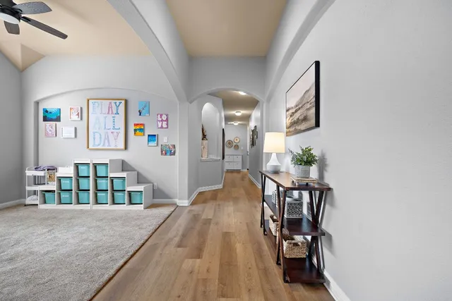 a view of a hallway to a livingroom with furniture
