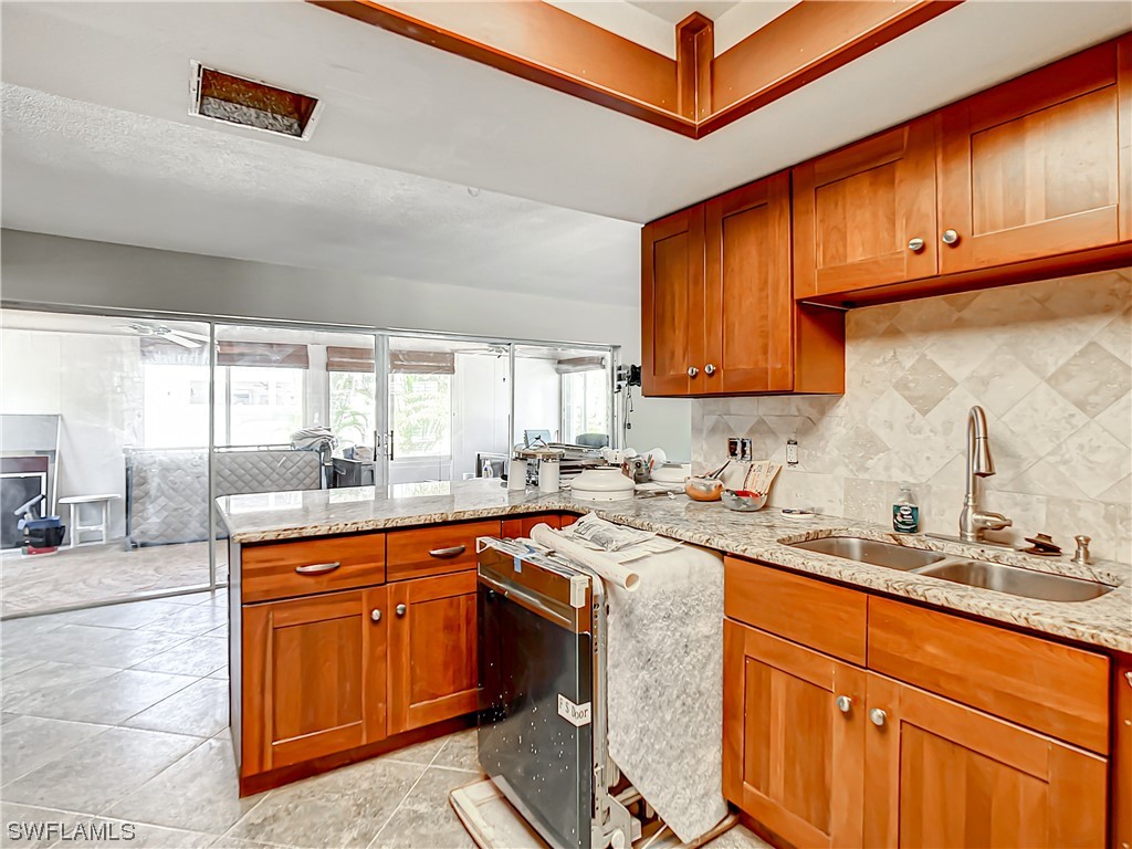 207 Redfish Road Fort Myers Beach, FL 33931 - Photo 12 of 50 a kitchen with stainless steel appliances granite countertop a sink a stove and a refrigerator