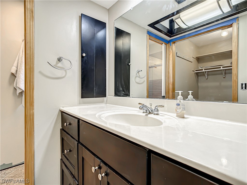 207 Redfish Road Fort Myers Beach, FL 33931 - Photo 25 of 50 a bathroom with a granite countertop sink a mirror and a shower