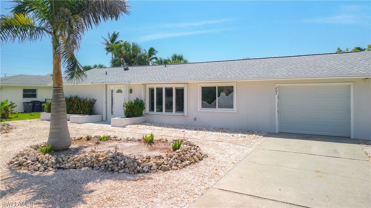 207 Redfish Road Fort Myers Beach, FL 33931 - Photo 3 of 50 a front view of a house with a yard