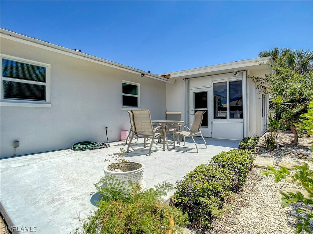 207 Redfish Road Fort Myers Beach, FL 33931 - Photo 40 of 50 a view of a patio with table and chairs and potted plants