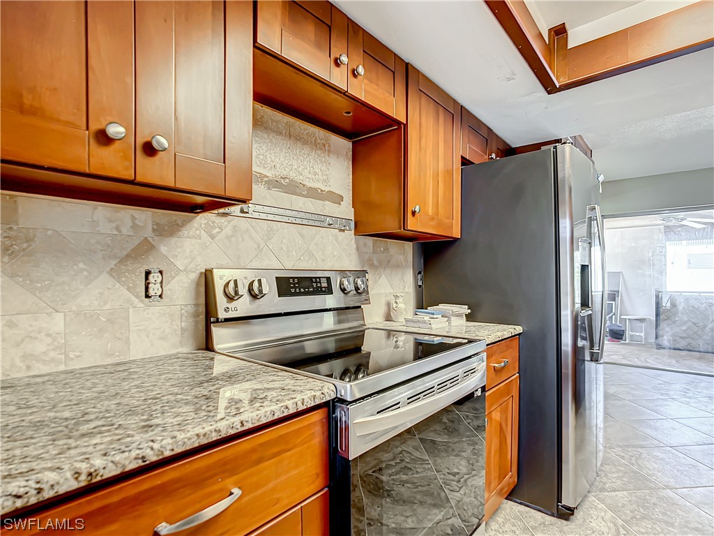 207 Redfish Road Fort Myers Beach, FL 33931 - Photo 8 of 50 a kitchen with stainless steel appliances granite countertop a refrigerator and a stove