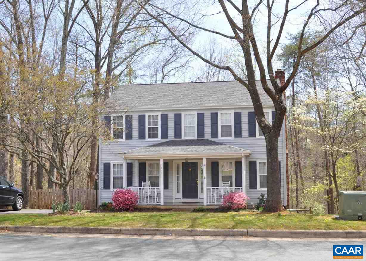 a front view of building with yard and trees around