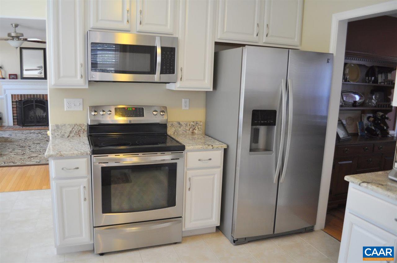 840 Harris Road Charlottesville, VA 22902 - Photo 7 of 11 a kitchen with stainless steel appliances white cabinets a stove a microwave and a refrigerator