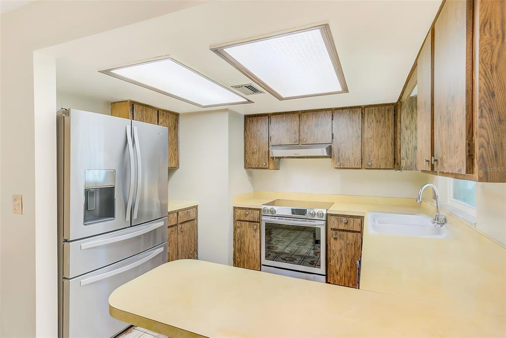 4707 East Temple Heights Road Tampa, FL 33617 - Photo 11 of 54 a kitchen with stainless steel appliances granite countertop a sink a stove and a refrigerator
