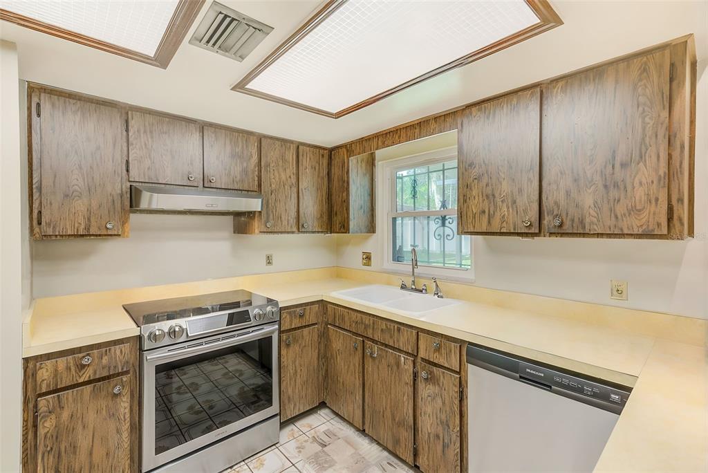 4707 East Temple Heights Road Tampa, FL 33617 - Photo 12 of 54 a kitchen with a sink stove and cabinets