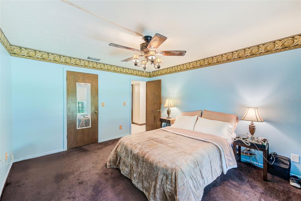 4707 East Temple Heights Road Tampa, FL 33617 - Photo 14 of 54 a bedroom with a bed and a chandelier