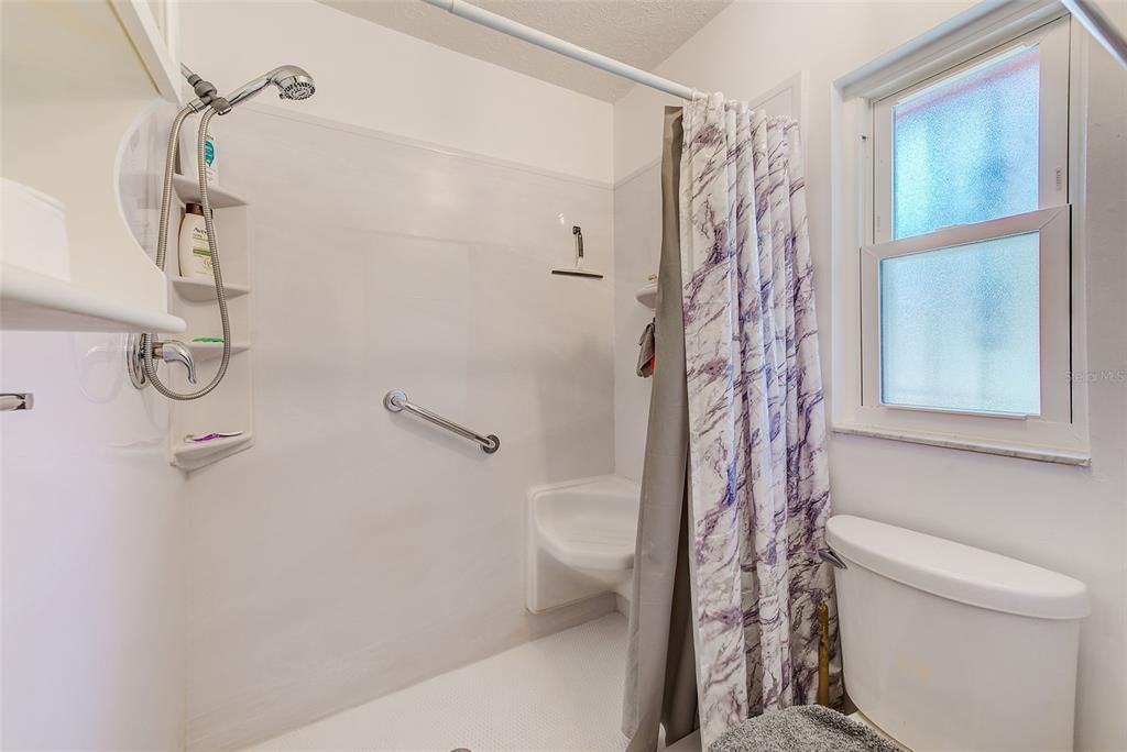 4707 East Temple Heights Road Tampa, FL 33617 - Photo 15 of 54 a bathroom with a shower curtain and a toilet