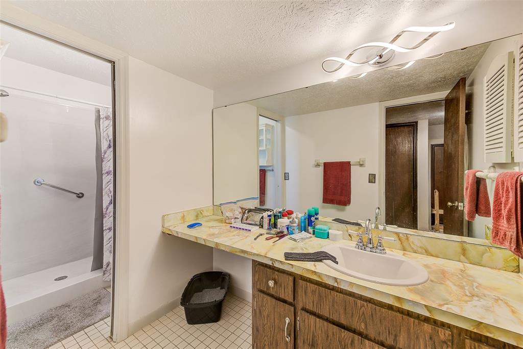 4707 East Temple Heights Road Tampa, FL 33617 - Photo 17 of 54 a bathroom with a granite countertop sink a toilet a mirror and shower
