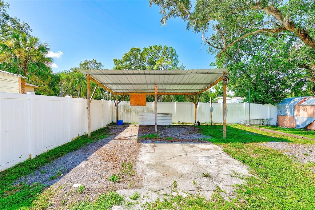 4707 East Temple Heights Road Tampa, FL 33617 - Photo 35 of 54 a view of a backyard with a garden and trees