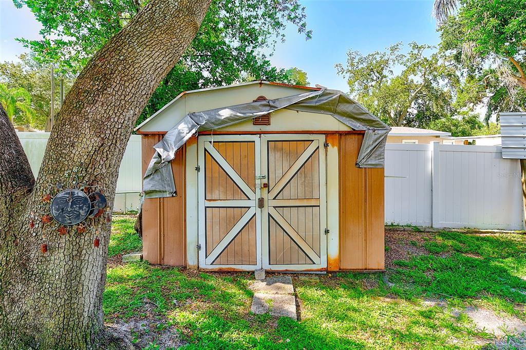 4707 East Temple Heights Road Tampa, FL 33617 - Photo 41 of 54 a view of a small house with a small yard and large trees