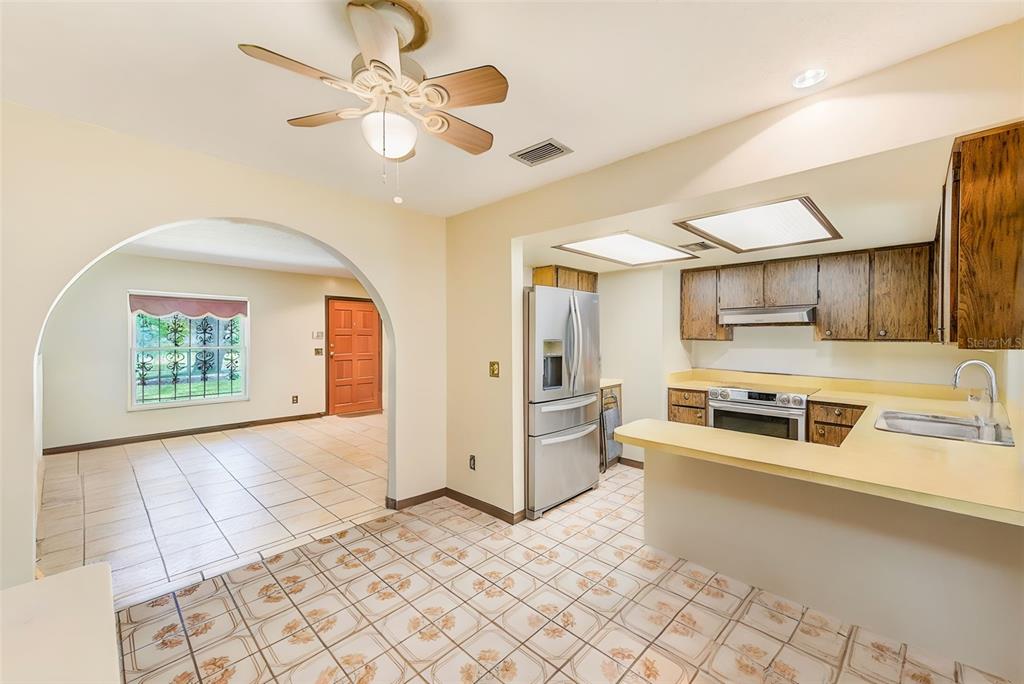 4707 East Temple Heights Road Tampa, FL 33617 - Photo 7 of 54 a large white kitchen with stainless steel appliances granite countertop a stove and a refrigerator with white cabinets