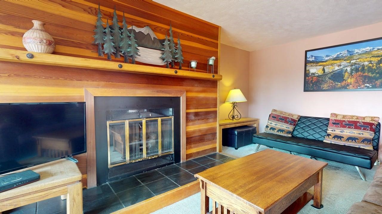 91200 Ryan Gulch Road, Unit 213 Silverthorne, CO 80498 - Photo 7 of 33 a living room with furniture a rug and a fireplace
