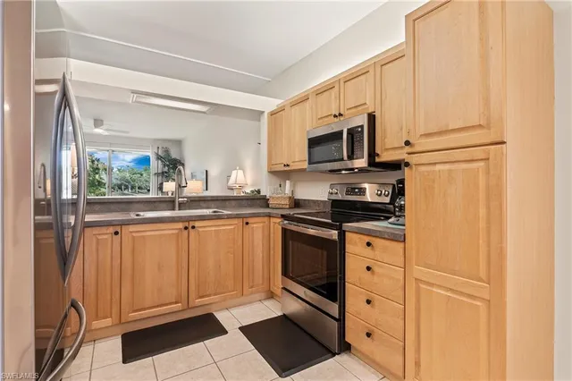 a kitchen with stainless steel appliances granite countertop a refrigerator a stove top oven and sink
