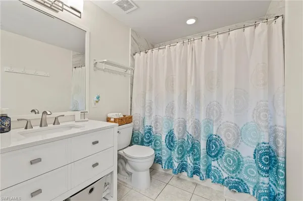 a bathroom with a granite countertop sink a toilet and a mirror