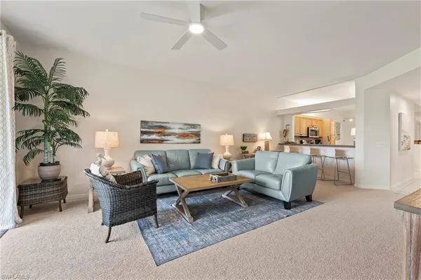 a living room with furniture and view of kitchen