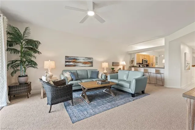 a living room with furniture and view of kitchen