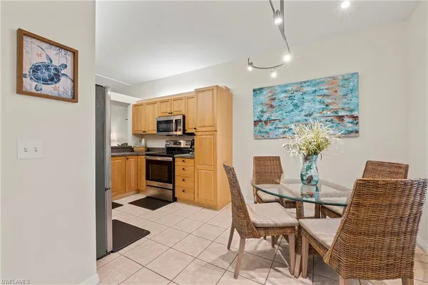 a dining room with furniture and kitchen view