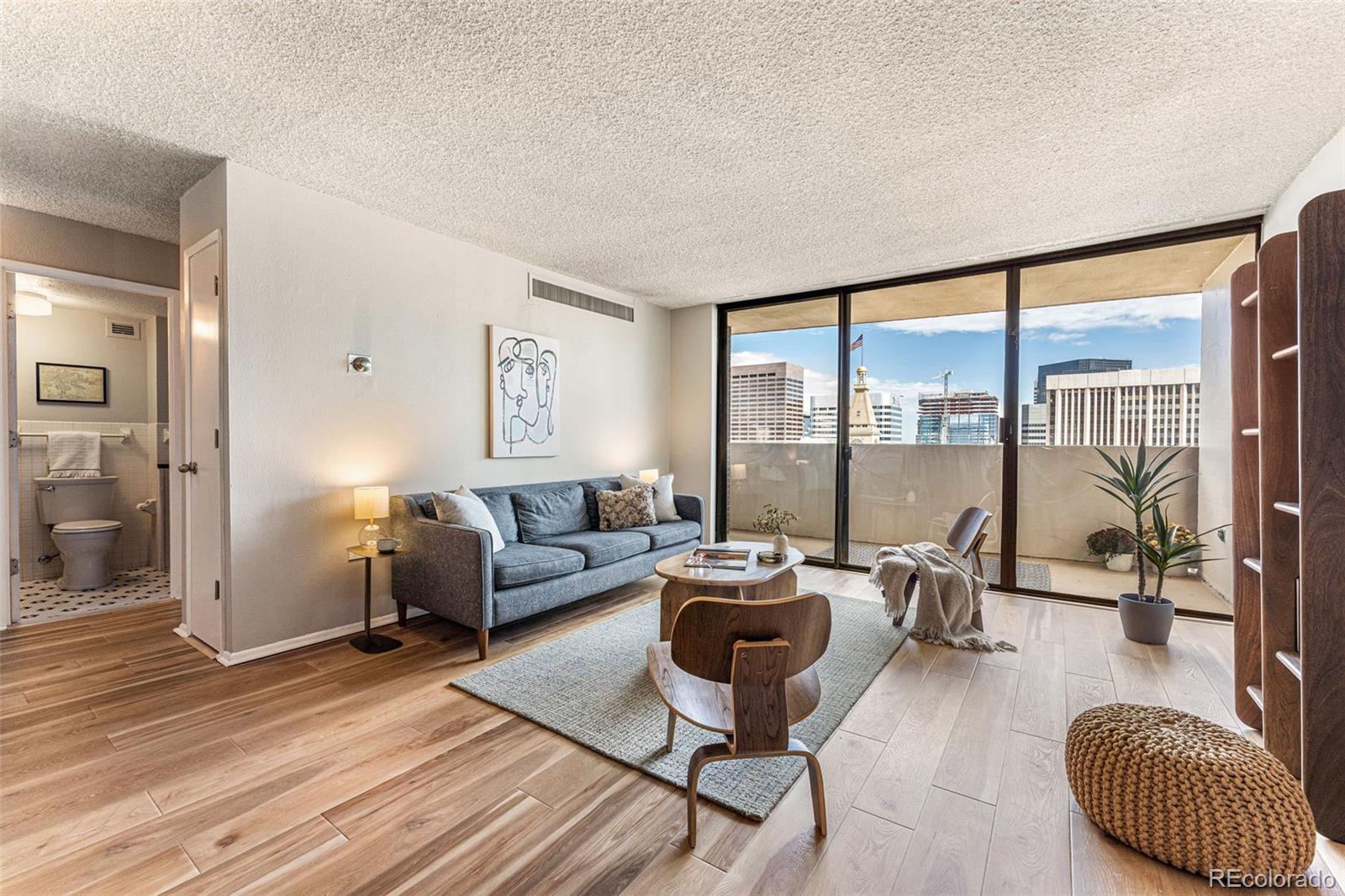 1020 15th Street, Unit 27E Denver, CO 80202 - Photo 1 of 3 a living room with furniture and a large window