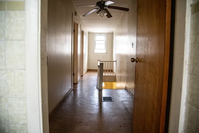 a view of a hallway with wooden floor fireplace and dining room