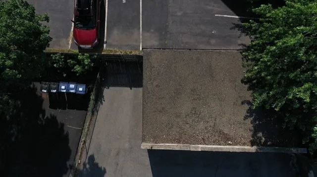 a view of city with the shops and cars parked