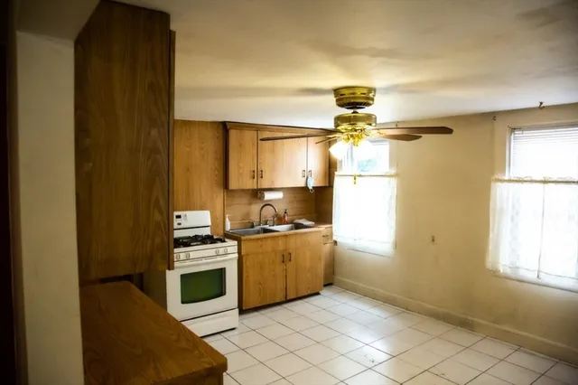 a kitchen with a stove a sink and a window