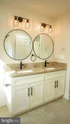 a bathroom with a granite countertop sink and mirror