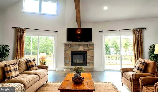 a living room with furniture a flat screen tv and a large window