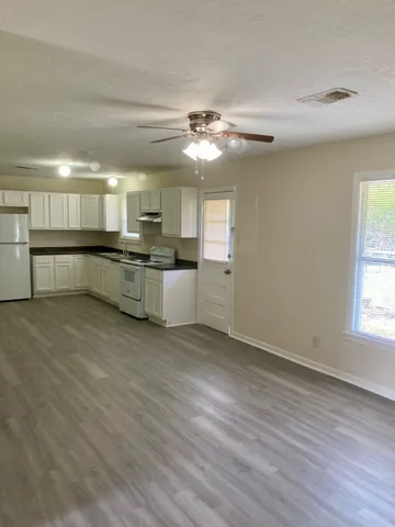 a large kitchen with a wooden floor and stainless steel appliances