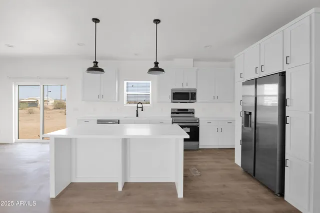 a kitchen with stainless steel appliances kitchen island sink refrigerator and stove