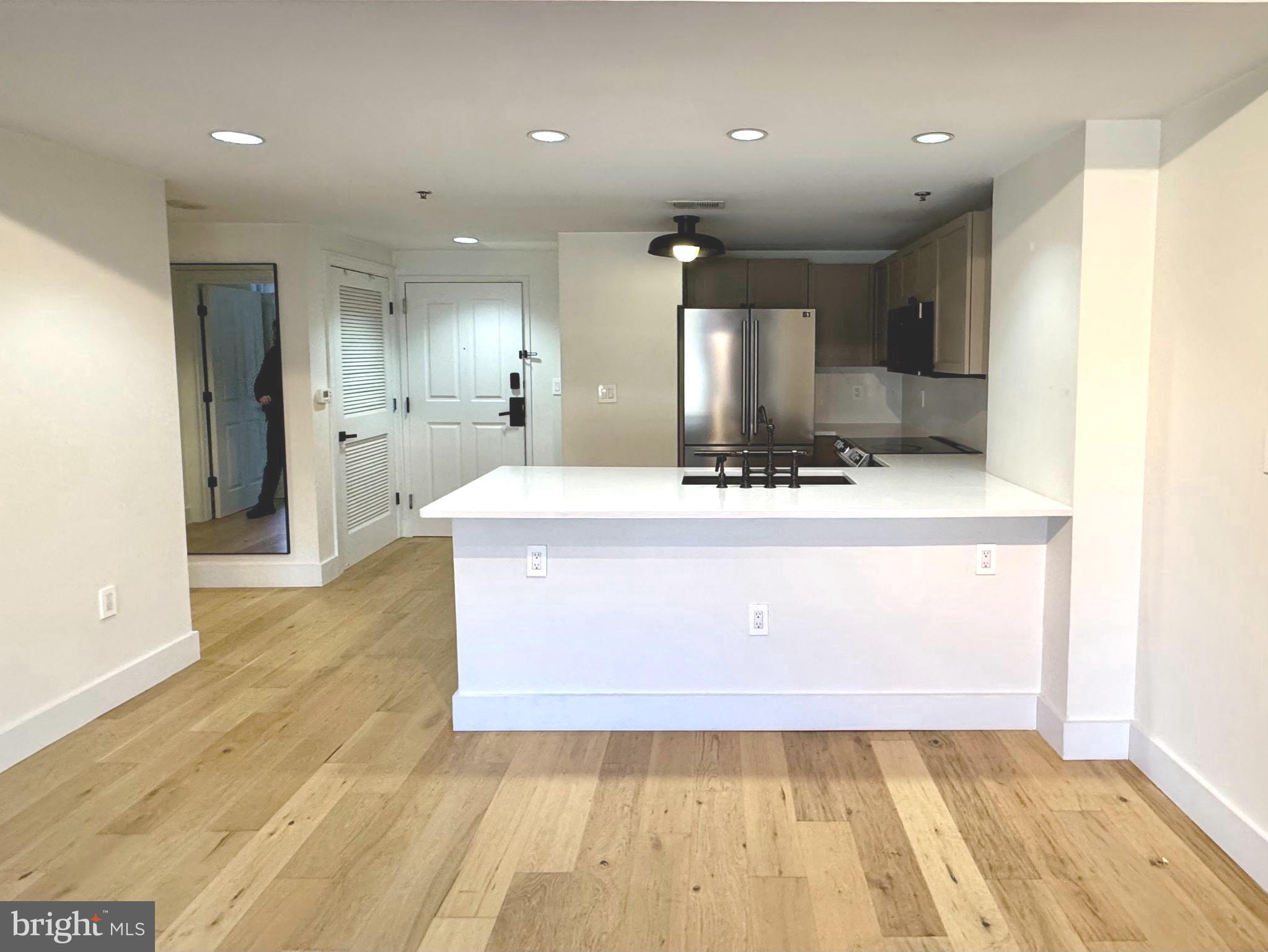 777 7th Street Northwest, Unit 322 Washington, DC 20001 - Photo 4 of 23 a large kitchen with stainless steel appliances a large counter top