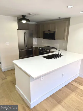 a kitchen with stainless steel appliances a refrigerator sink and microwave
