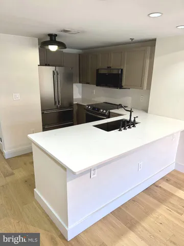 a kitchen with stainless steel appliances a stove a microwave and white cabinets