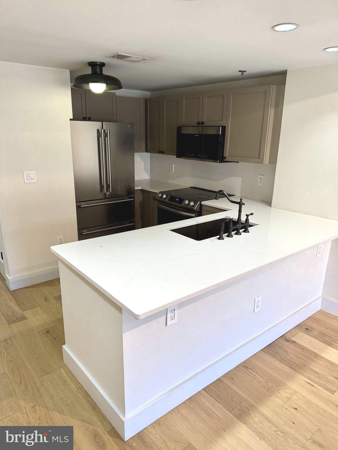 777 7th Street Northwest, Unit 322 Washington, DC 20001 - Photo 5 of 23 a kitchen with stainless steel appliances a refrigerator sink and microwave