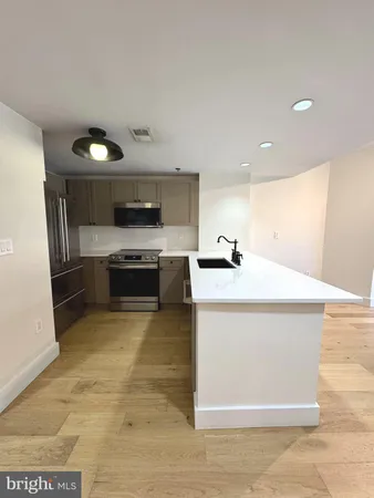 a kitchen with stainless steel appliances a stove a microwave and a sink