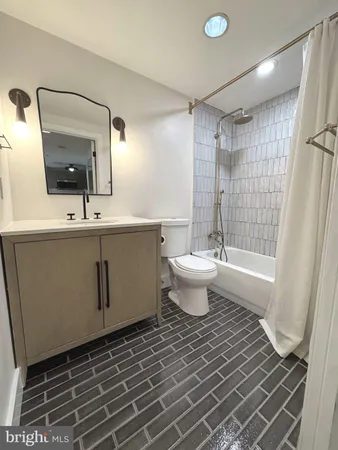 a bathroom with a sink toilet a mirror and shower