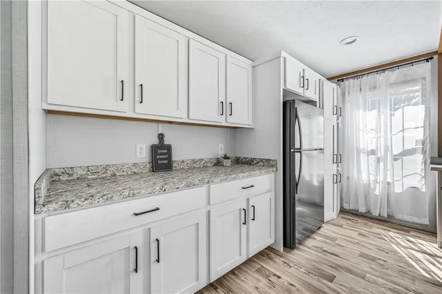 a kitchen with granite countertop a sink cabinets and stainless steel appliances